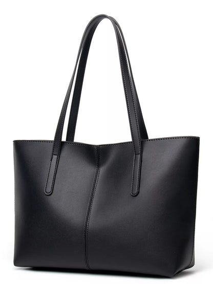 A black faux-leather tote bag with dual shoulder straps, shown from a three-quarter angle on a plain white background.