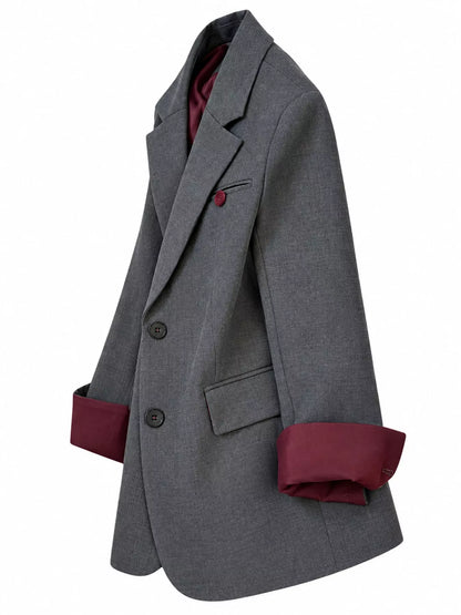A gray double-breasted blazer with a contrasting burgundy lining visible on the inner collar, cuffs, and pocket square, shown against a plain white background.