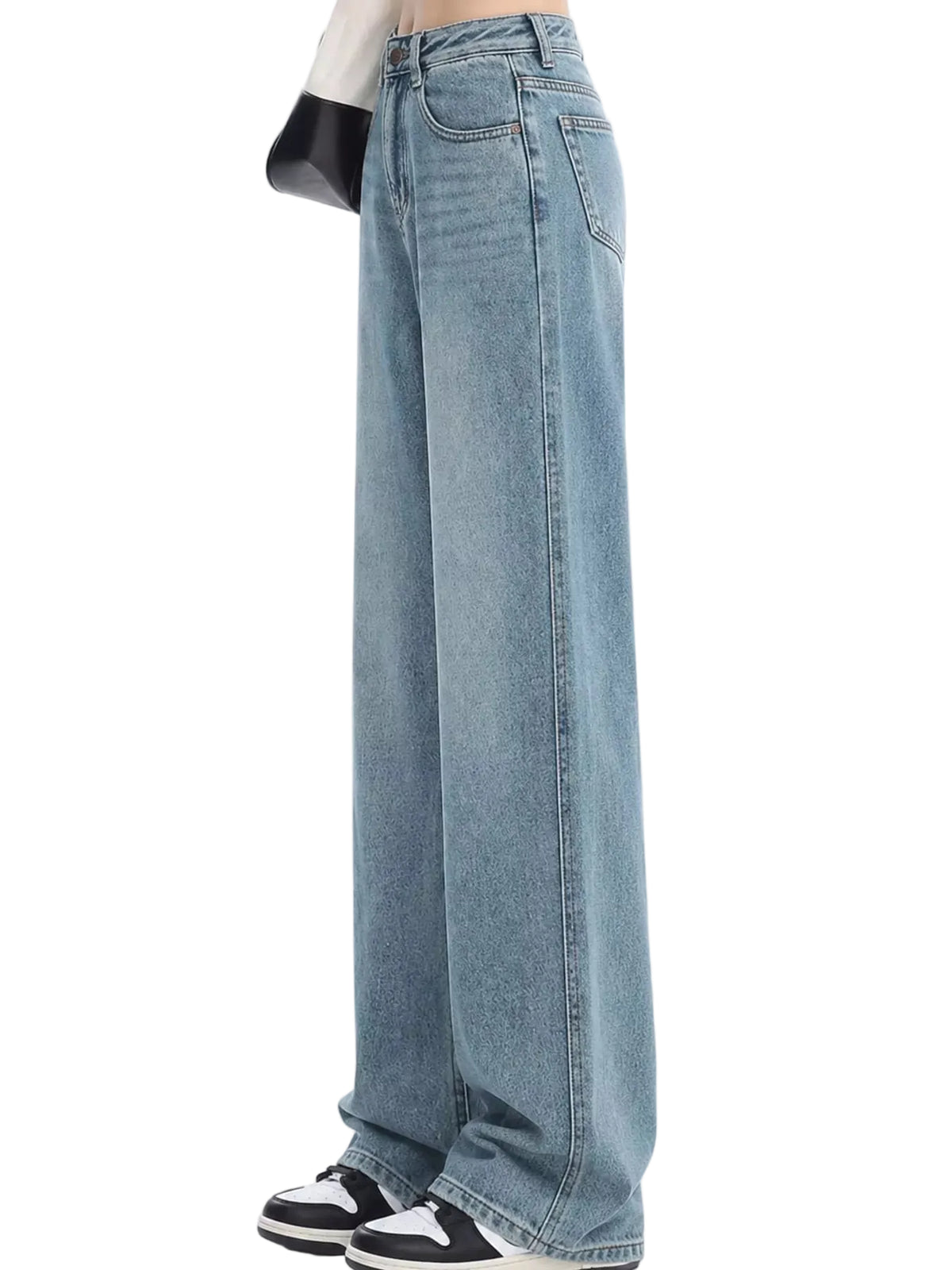 Light blue wide-leg denim jeans shown on a model from the waist down, paired with black and white sneakers against a plain white background.