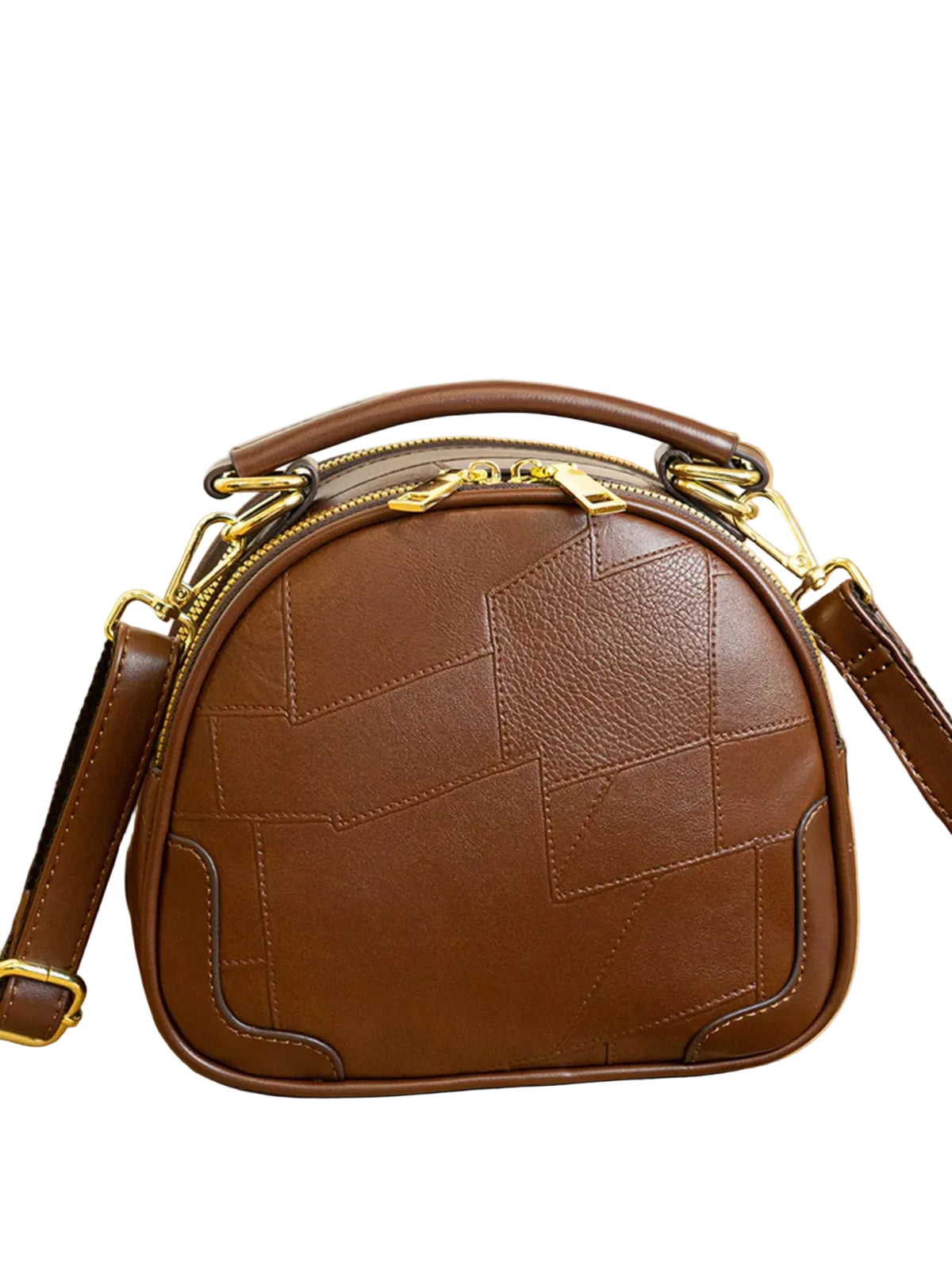 A brown leather dome-shaped handbag with geometric stitched paneling and gold-tone hardware, displayed on a light wood surface with a Chanel perfume bottle in the background.