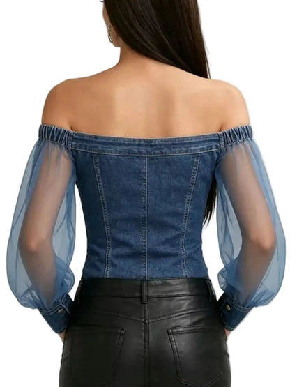 A woman shown from the back wearing a blue denim off-the-shoulder top with sheer puff sleeves and black leather pants, against a light gray studio background.