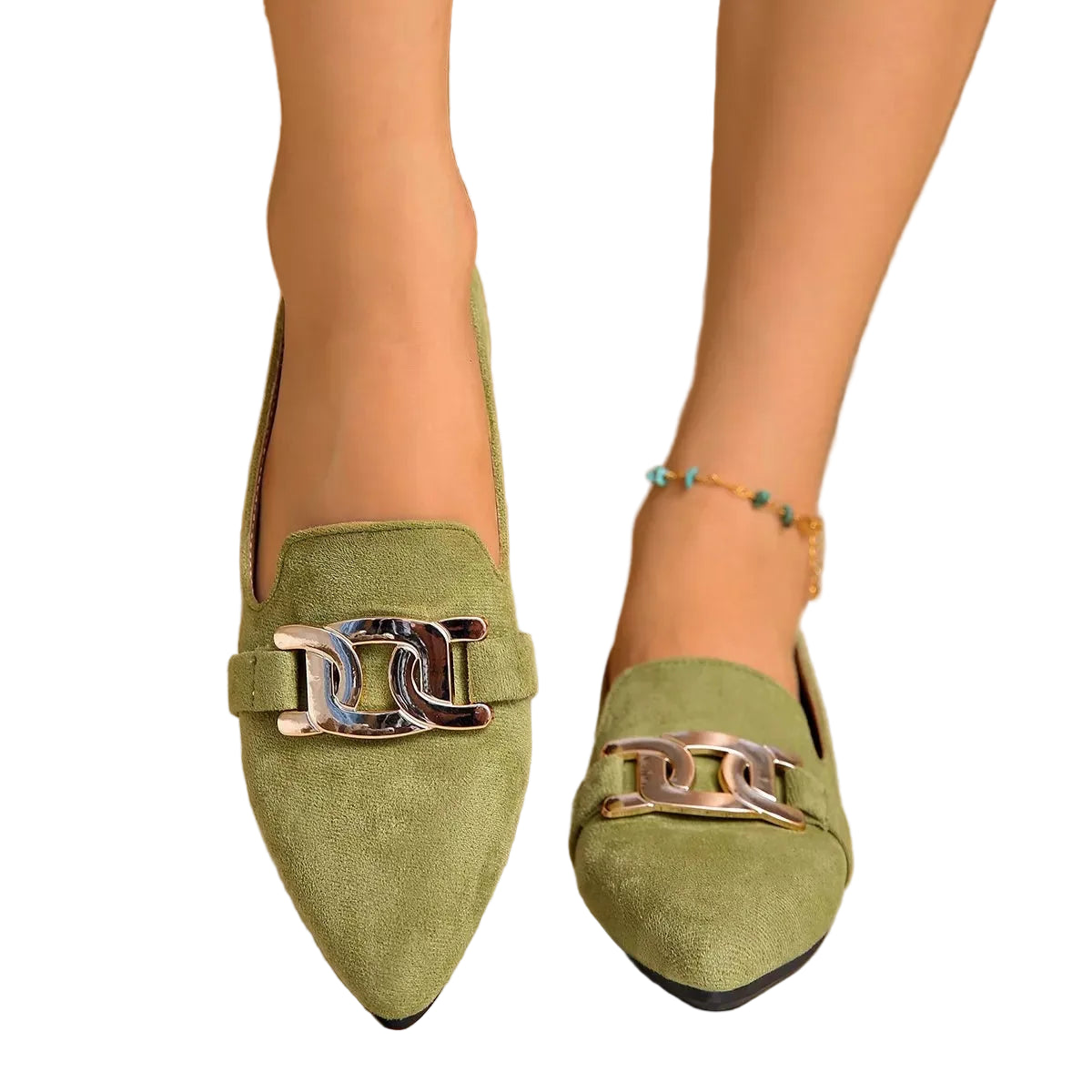 A pair of women's pointed-toe loafers in sage green suede with a shiny silver-tone chain detail across the top, shown being worn on feet against a neutral indoor background.