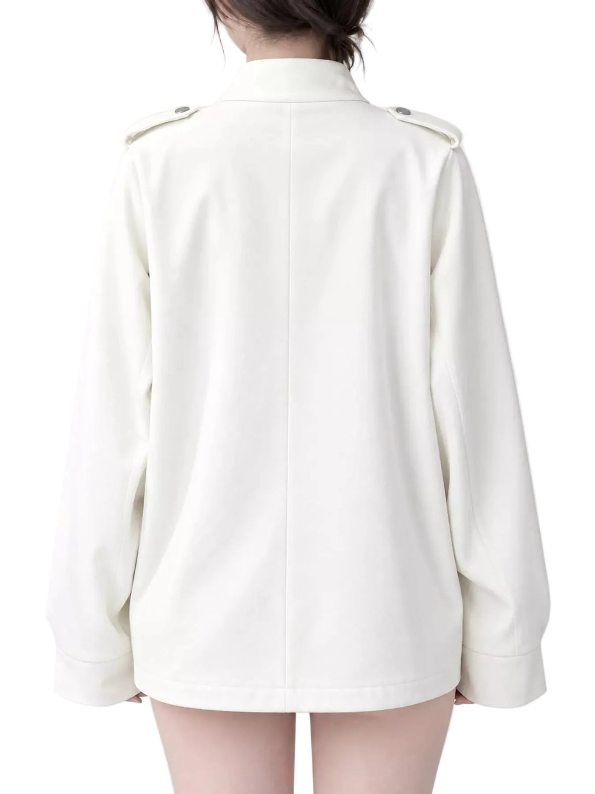 A person shown from the back wearing a long-sleeve cream-colored jacket with shoulder epaulets, photographed against a plain light gray studio background.