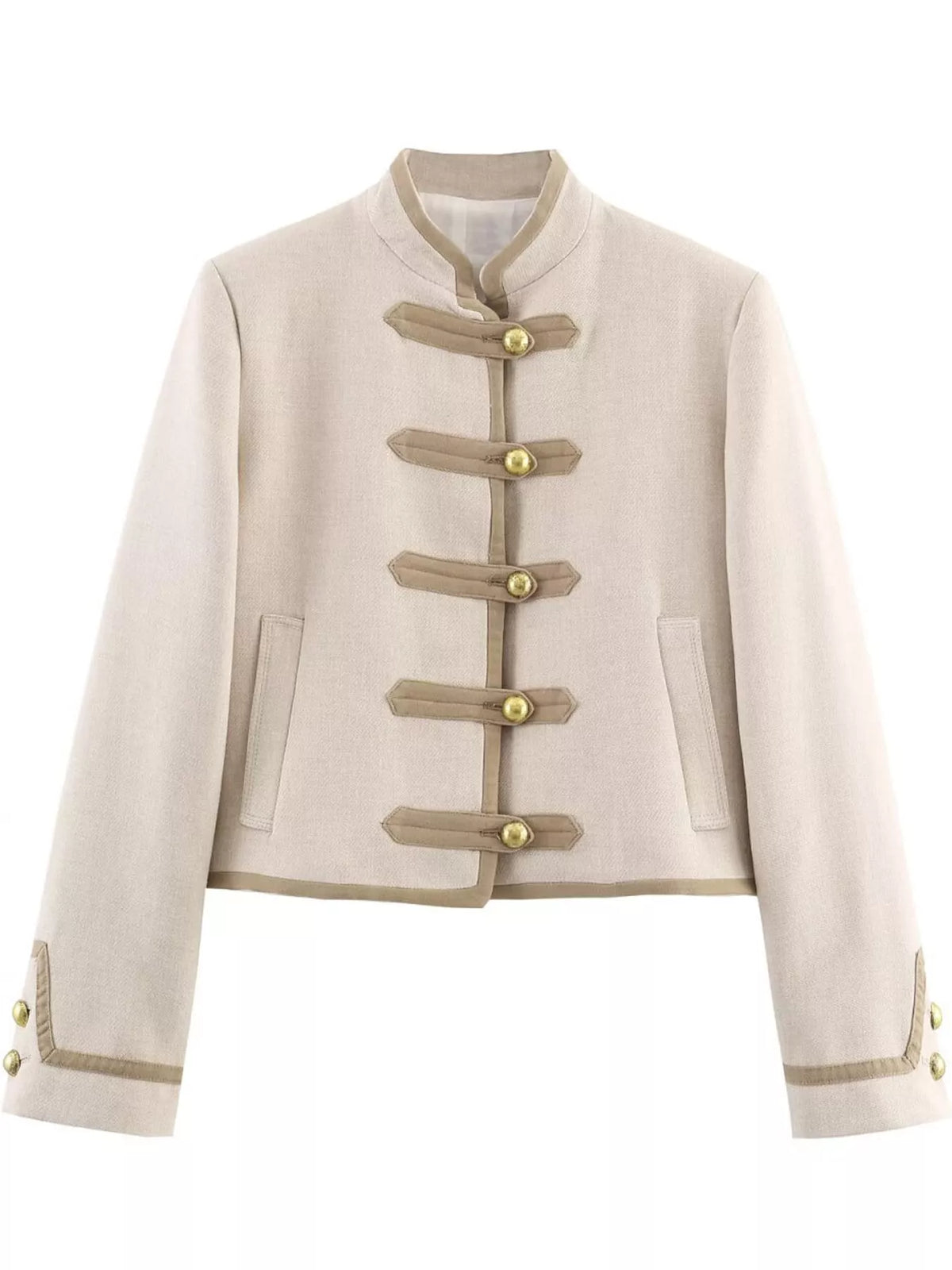 A cropped beige jacket with a mandarin collar, featuring decorative strap-and-button front closures and side pockets, shown against a plain white background.