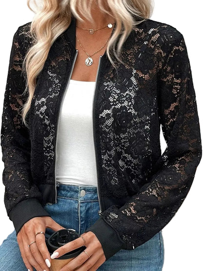 A woman wearing a black lace bomber jacket over a white tank top and blue jeans, holding a coffee cup.