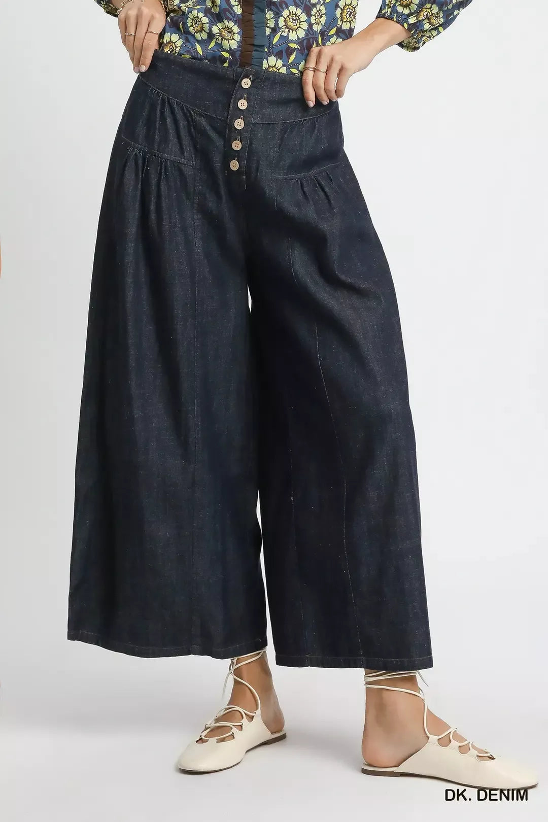 Person wearing dark denim wide-leg pants on a white background