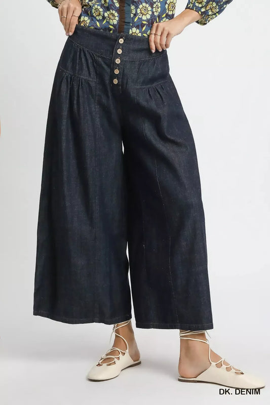 Person wearing dark denim wide-leg pants on a white background