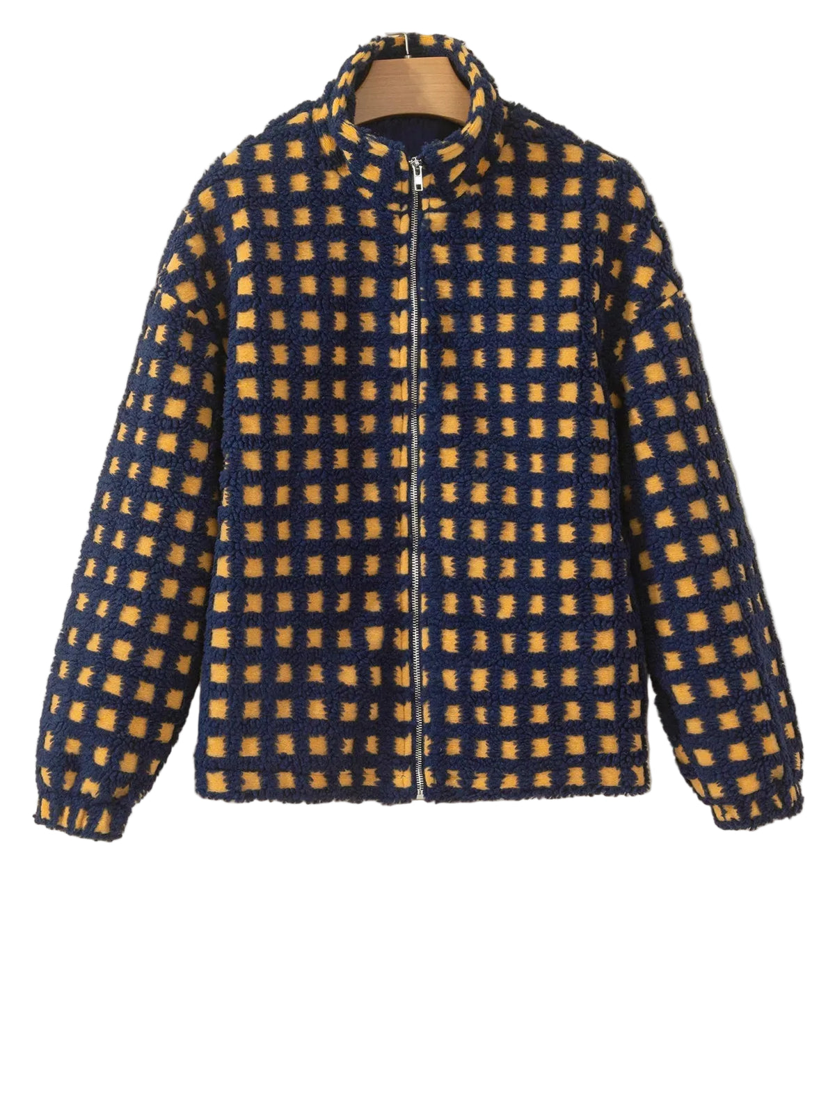 A fuzzy zip-up jacket with a blue and mustard yellow checkered pattern, hanging on a wooden hanger against a plain beige wall.