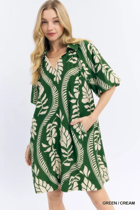 Woman wearing a green and cream leaf-patterned dress on a white background