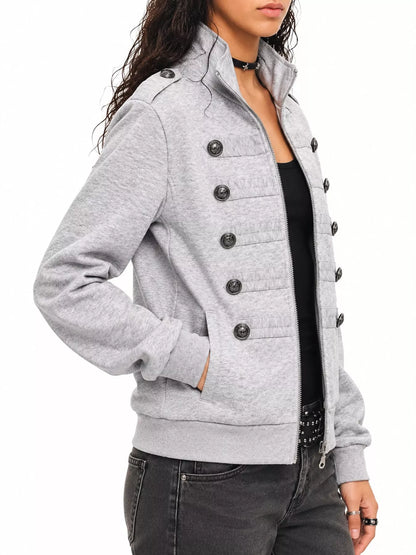 A woman wearing a light gray heathered double-breasted jacket with large dark buttons, styled over a black top and dark gray jeans against a plain white background.