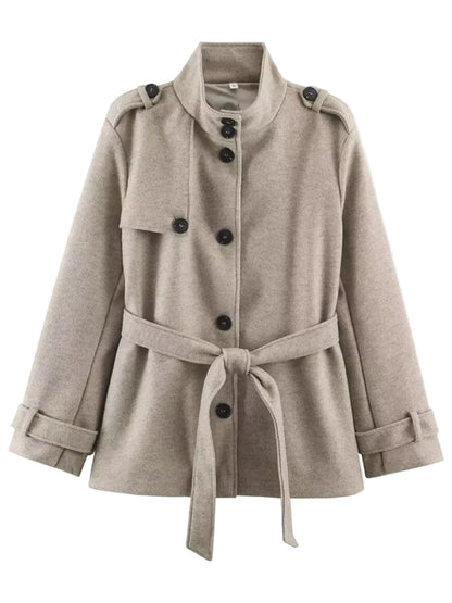 A light taupe-beige belted coat with a high stand collar, double-breasted front, and shoulder epaulets, shown against a plain white background.