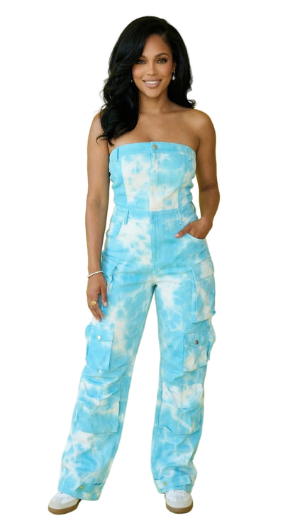 Woman wearing a blue tie-dye strapless jumpsuit on a yellow background
