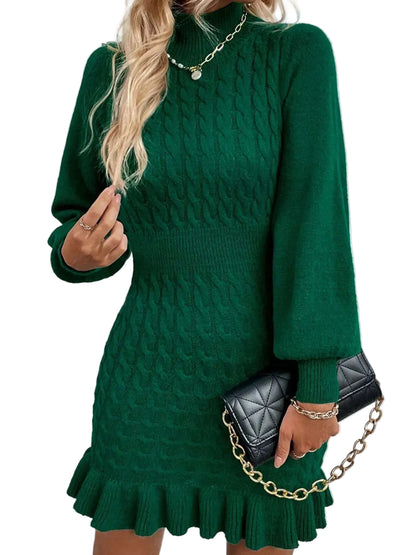 A woman wearing a dark green cable-knit mock-neck sweater dress with balloon sleeves and a ruffled hem, holding a black quilted handbag with a gold chain strap.