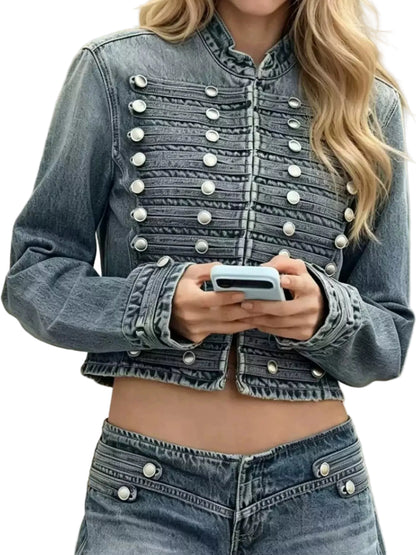 A cropped blue denim jacket with decorative silver military-style buttons, worn by a model holding a light blue smartphone.