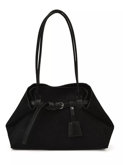 A black canvas shoulder bag with black leather handles and a front tie detail, shown against a plain white background.