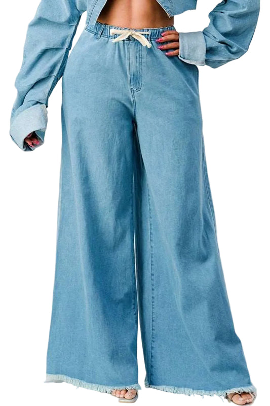 Person wearing light blue denim pants on a white background