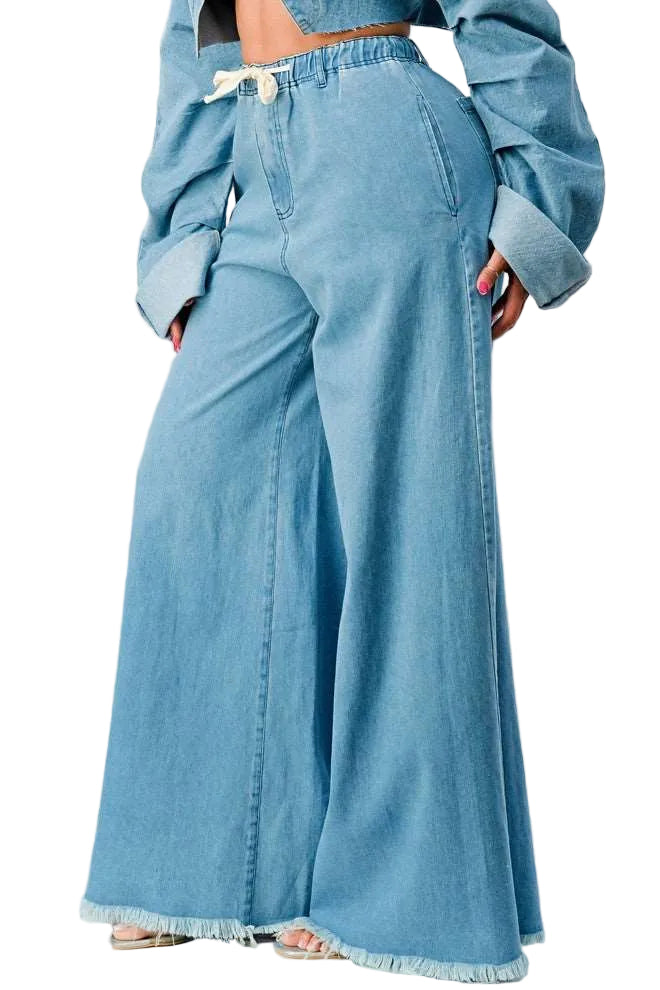 Person wearing a blue denim outfit with wide-leg pants on a white background