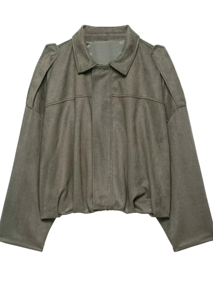 An oversized, cropped utility jacket in a muted olive green color, featuring a pointed collar, structured shoulders, and a front button closure, shown against a plain white background.