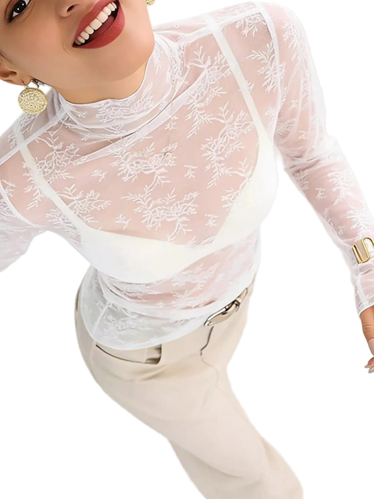 A woman wearing a sheer white floral lace mock-neck long-sleeve top over a white bralette, paired with beige trousers, shown against a plain white background.