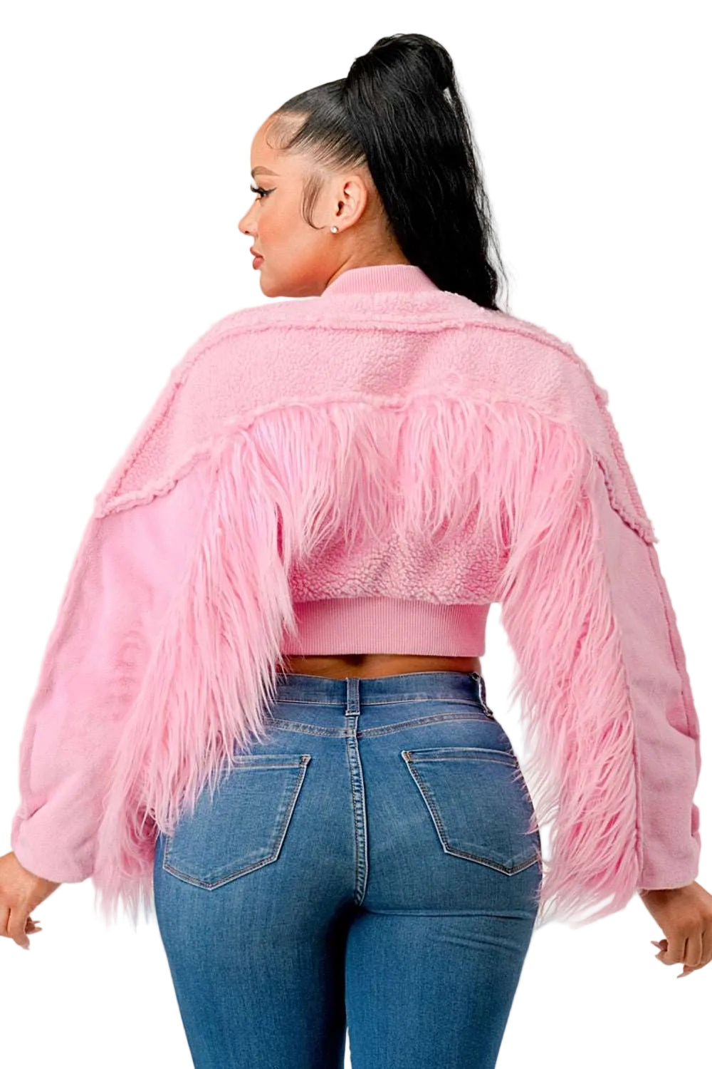 Person wearing a pink fringed jacket and blue jeans on a plain background