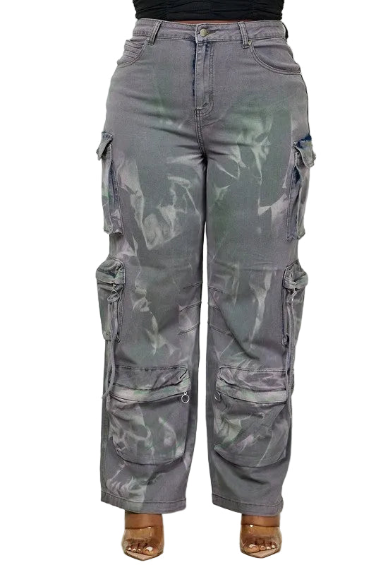 Gray camouflage cargo pants worn by a person on a white paneled wall background