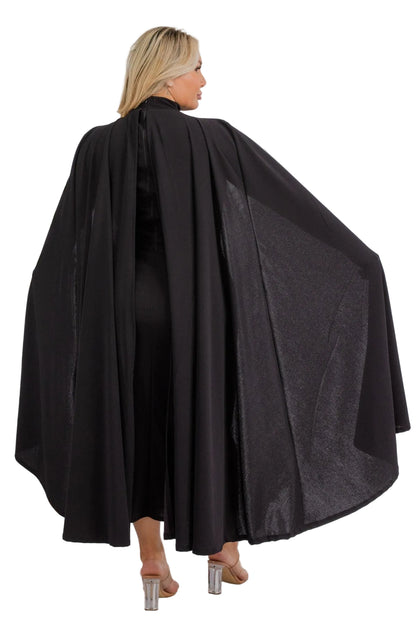 Woman wearing a black cape against a white background