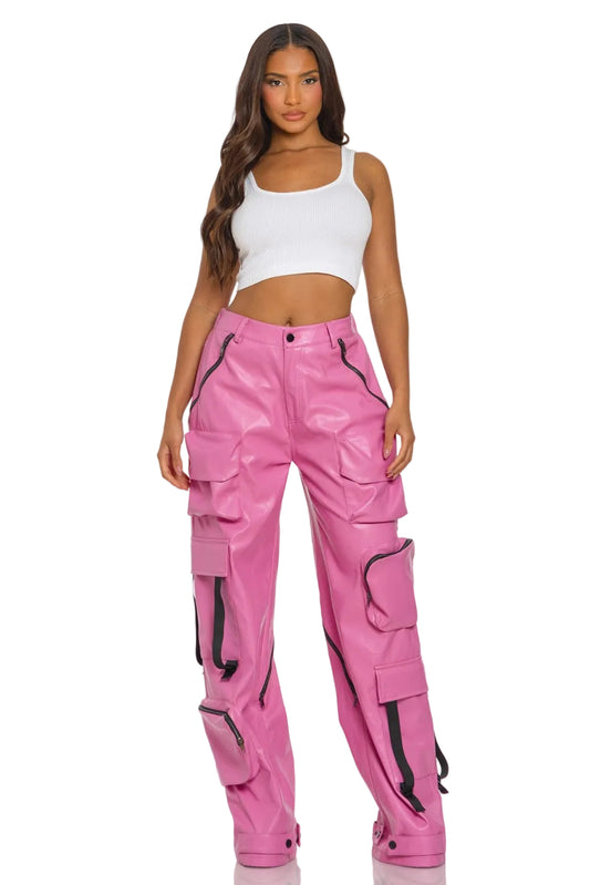 Woman wearing pink cargo pants with black zippers on a white background