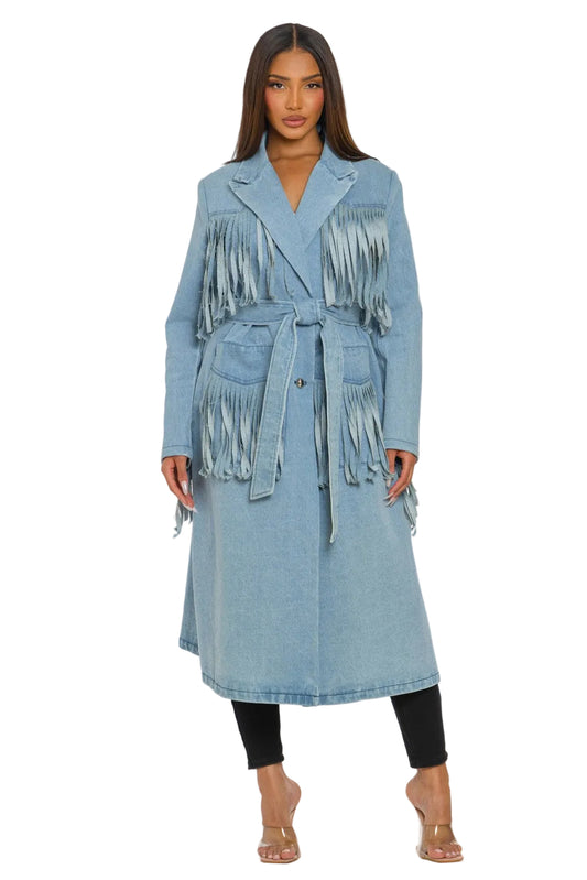 Woman wearing a light blue denim coat with fringe details on a white background