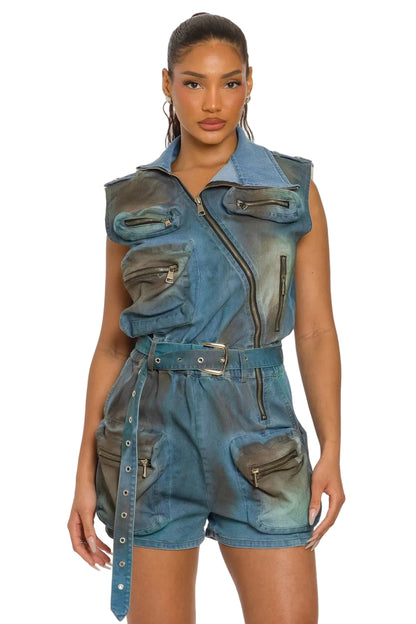 Woman wearing a denim romper with leather accents on a white background