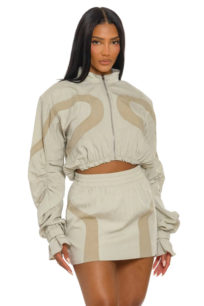 Woman wearing a beige and brown patterned outfit on a white background