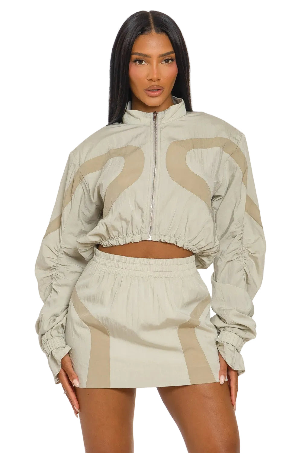 Woman wearing a beige and brown tracksuit on a white background