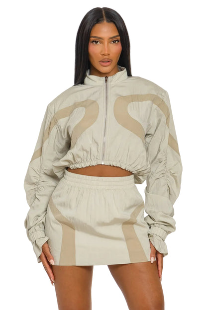 Woman wearing a beige and brown tracksuit on a white background