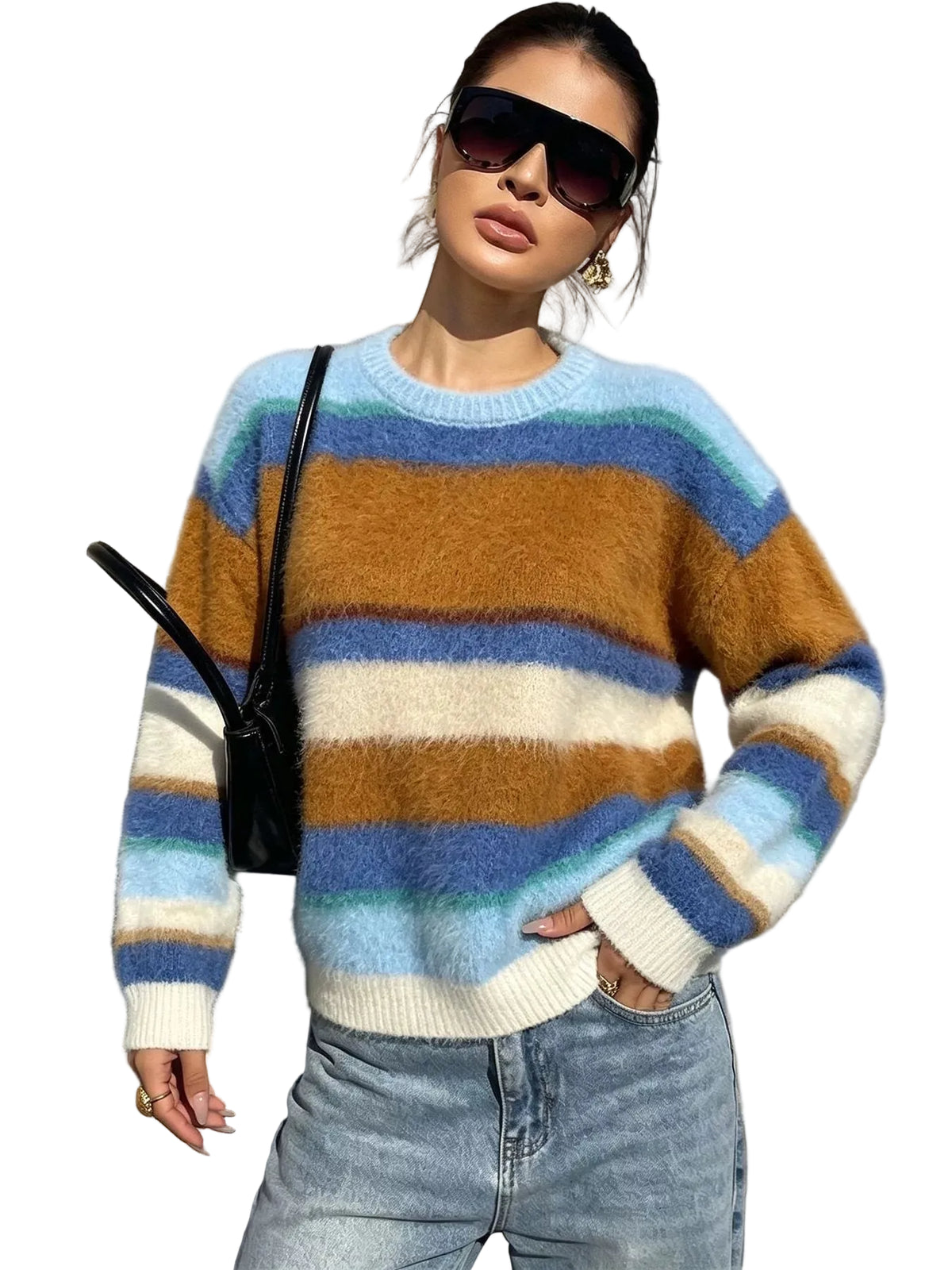 A woman wearing a fuzzy crewneck sweater with horizontal stripes in light blue, mustard brown, cream, and teal, paired with light-wash jeans and black sunglasses, standing against a gray stone wall.