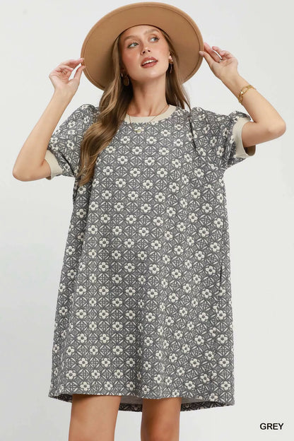Woman wearing a patterned dress and beige hat on a white background
