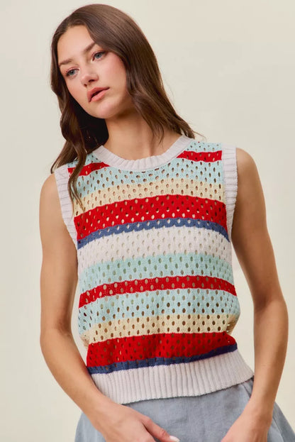 Woman wearing a colorful sleeveless sweater with a neutral background