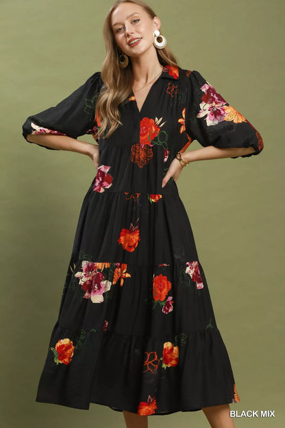 Woman wearing a black floral dress against a green background