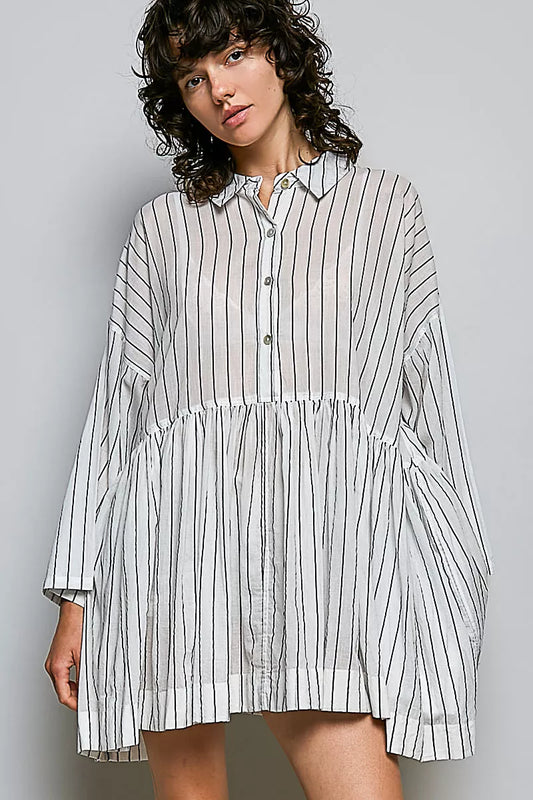 Woman wearing a striped shirt dress against a gray background