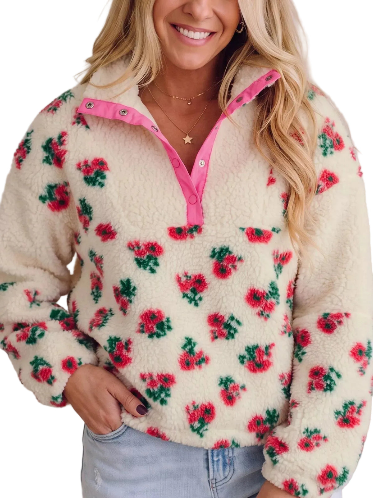 A woman wearing a cream-colored sherpa fleece quarter-zip pullover with a red and green floral pattern, featuring a pink zipper and collar trim.