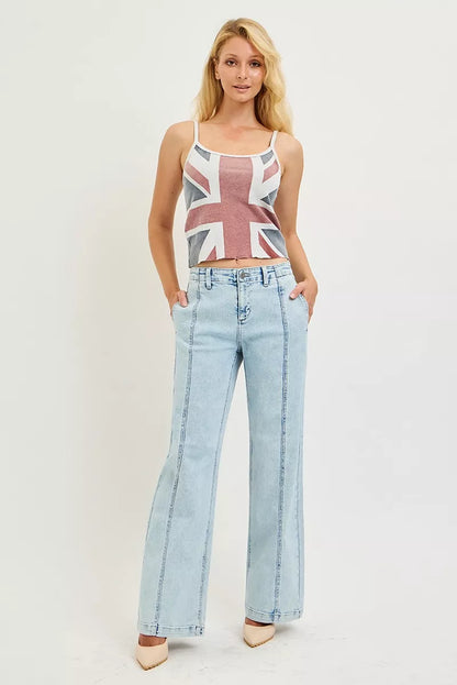 Woman wearing a tank top with a Union Jack design and light blue jeans on a white background