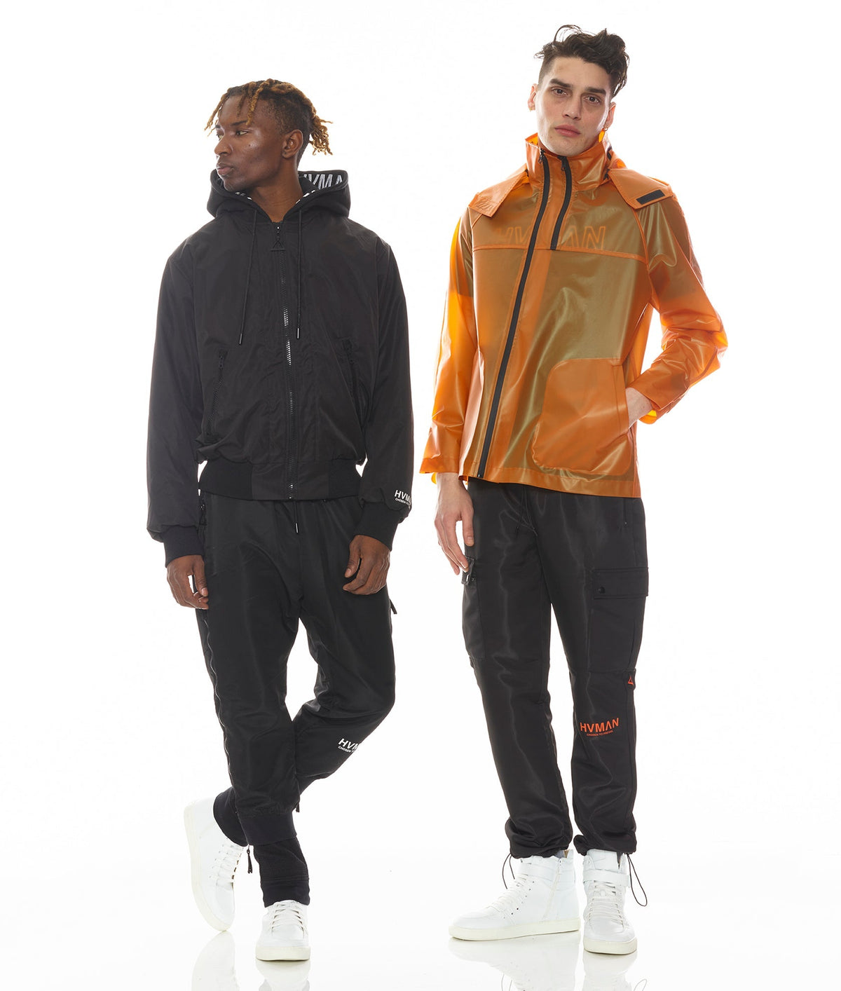 Two people wearing black and orange raincoats on a white background