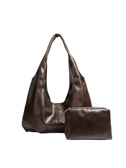 A dark brown leather hobo shoulder bag with a matching zippered pouch, displayed on a light gray background.