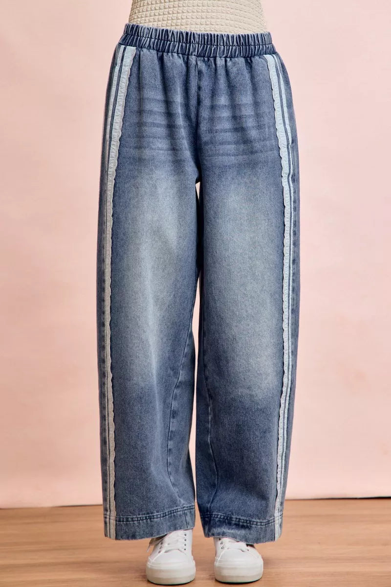 Blue denim pants with white stripes on a pink background