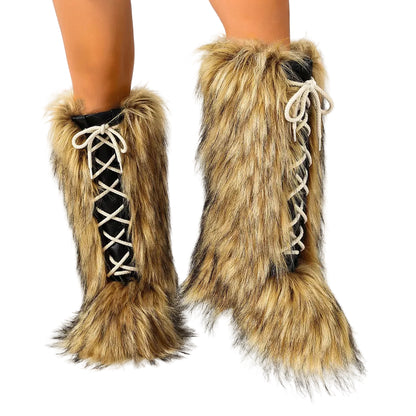 A pair of tall faux-fur leg warmers worn on a model's legs, featuring a black lace-up front with white laces and a fluffy tan and black faux-fur exterior.