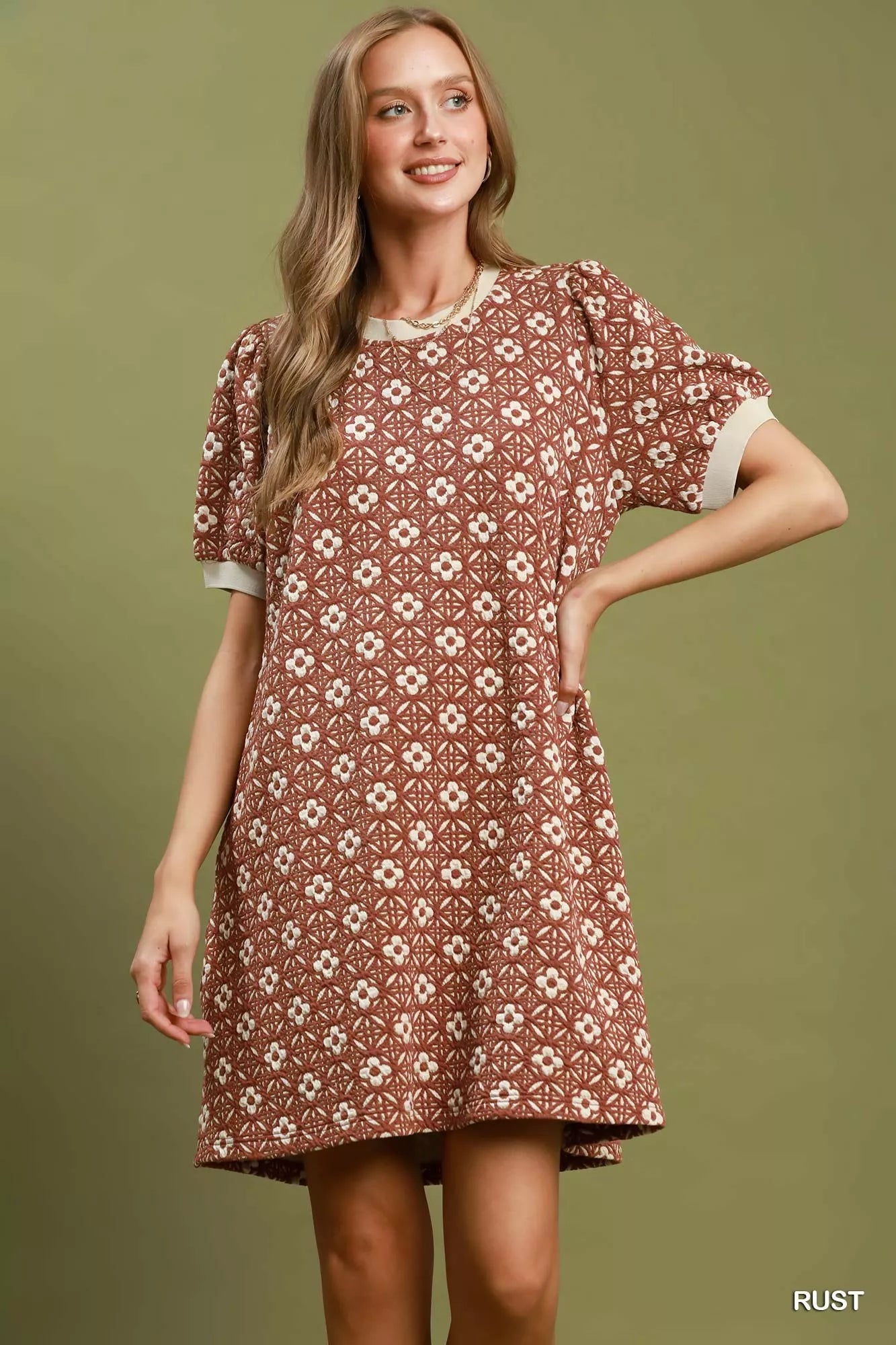 Woman wearing a patterned dress on a solid background
