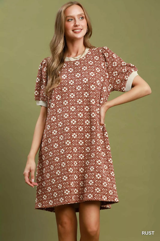 Woman wearing a patterned dress on a solid background