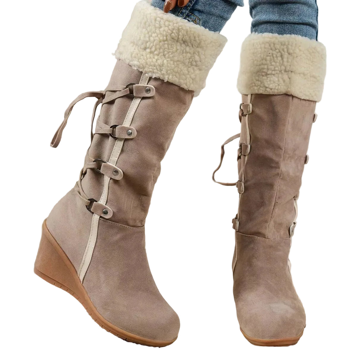 A pair of knee-high taupe suede boots with a cream sherpa lining at the top, side laces with metal buckles, and wedge heels, shown on a person wearing blue jeans.