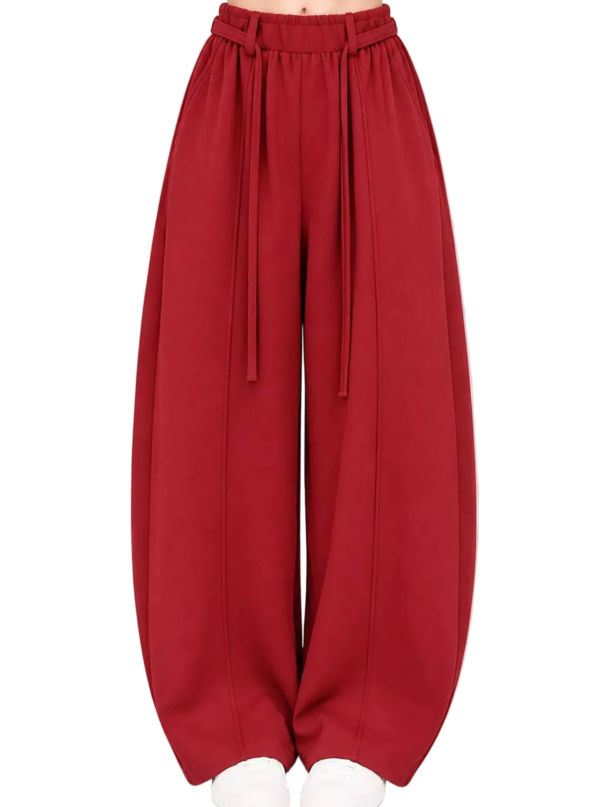 A pair of wide-leg, balloon-style pants in a deep red or burgundy color, featuring an elastic waistband with hanging drawstrings, shown on a model from the waist down against a plain white background.