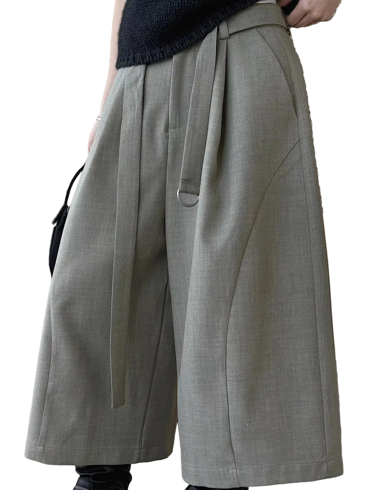 A person wearing wide-leg pleated trousers in a light gray color, paired with a dark knit top. The photo is cropped from the chest down, showing the fit and drape of the pants against an indoor background.
