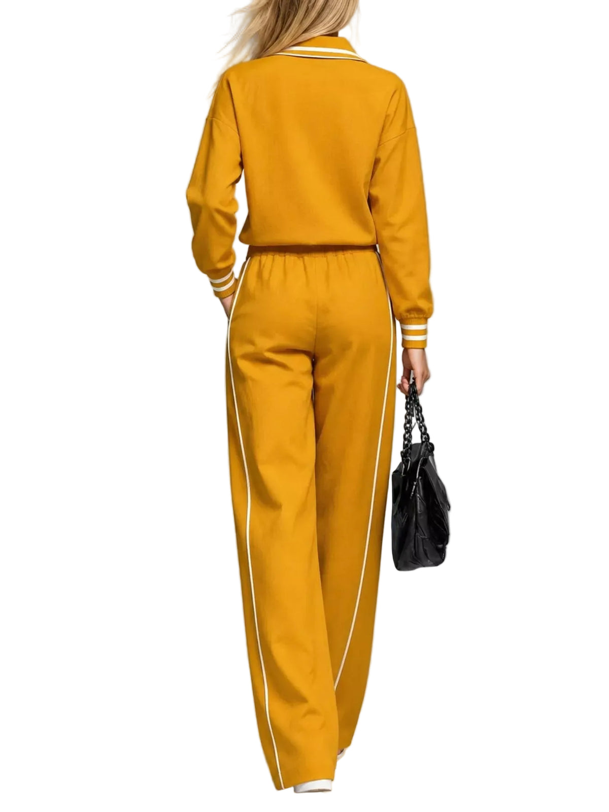 A woman shown from the back wearing a matching mustard yellow tracksuit with white stripe details on the collar, cuffs, and down the side of the pants. She is holding a black handbag against a neutral gray studio background.