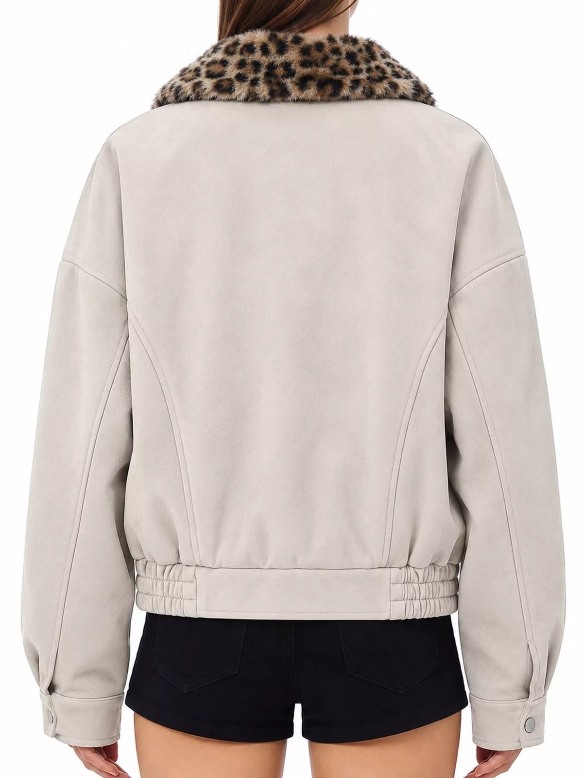 A person shown from the back wearing a light beige cropped jacket with a leopard-print faux-fur collar and black shorts against a plain white background.